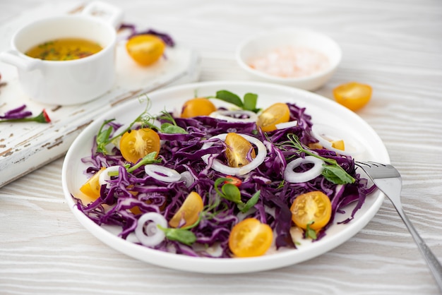 Ensalada de col lombarda, tomates cherry amarillos y cebollas