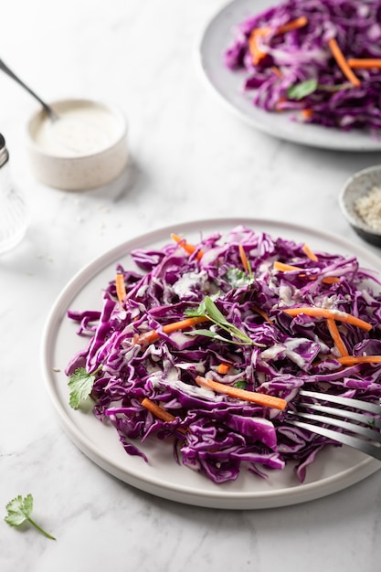 Ensalada de col lombarda con zanahoria en una mesa de luz. Concepto de comida sana.