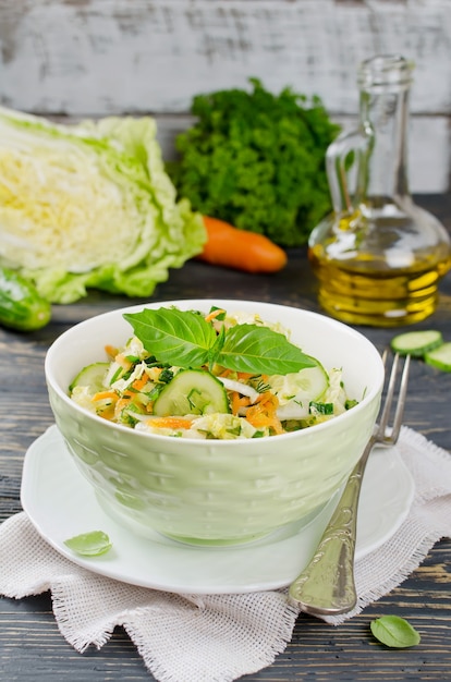 Ensalada de col con pepino. Ensalada y verduras en mesa de madera