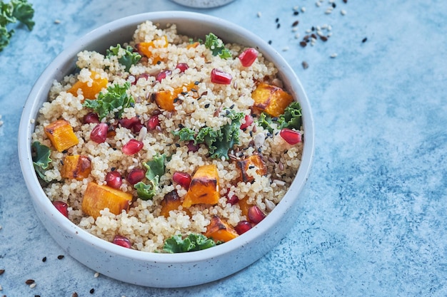 Ensalada de col rizada, calabaza, calabaza, granada y quinoa