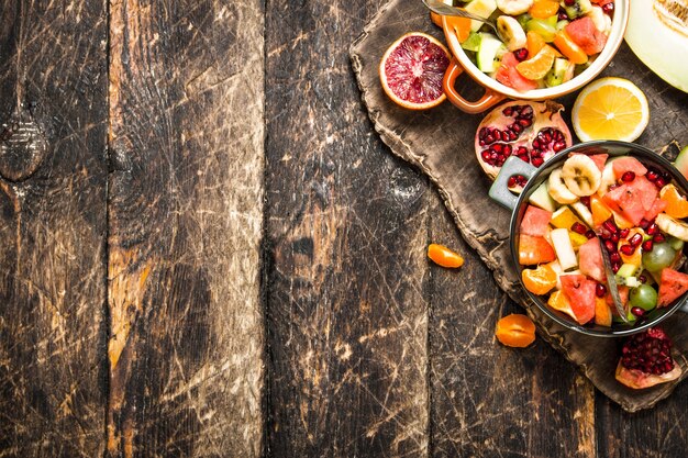 Ensalada de comida de verano de frutas tropicales sobre fondo de madera