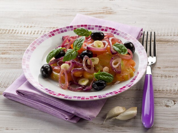 Ensalada con corazón de buey tomates cebollas aceitunas y ajo