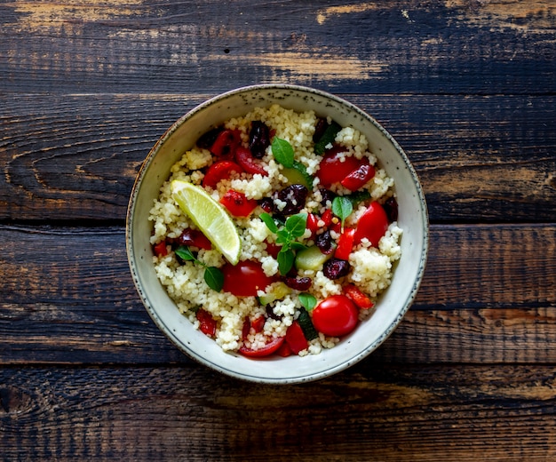 Ensalada de cuscús con tomates, pimientos, calabacines y arándanos. Comida vegetariana. Dieta. Alimentación saludable.