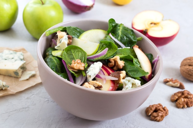 Ensalada de dieta dieta deliciosa con espinacas, manzanas, cebollas rojas, queso azul, nueces