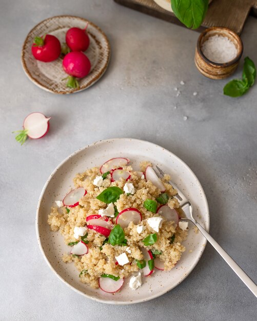 Ensalada de dieta con quinua, queso feta, rábano y albahaca en un plato de cerámica. concepto de comida saludable