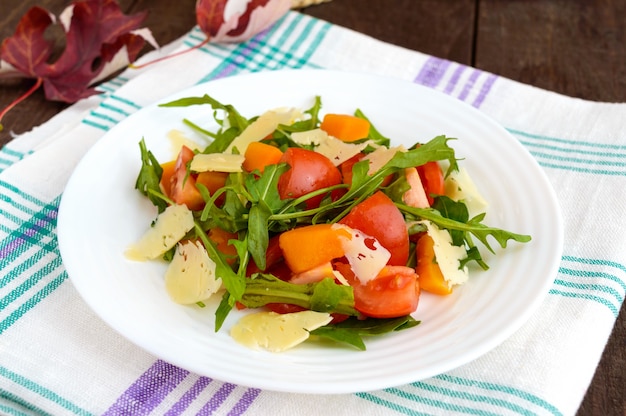 Ensalada dietética con calabaza, tomates frescos, rúcula y parmesano.