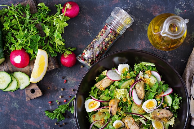 Ensalada dietética con mejillones, huevos de codorniz, pepinos, rábanos y lechuga. Ensalada de mariscos.