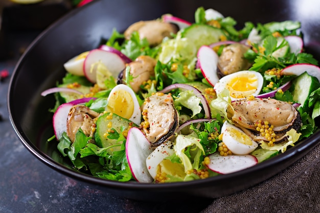 Ensalada dietética con mejillones, huevos de codorniz, pepinos, rábanos y lechugas. Comida sana. Ensalada de mariscos.