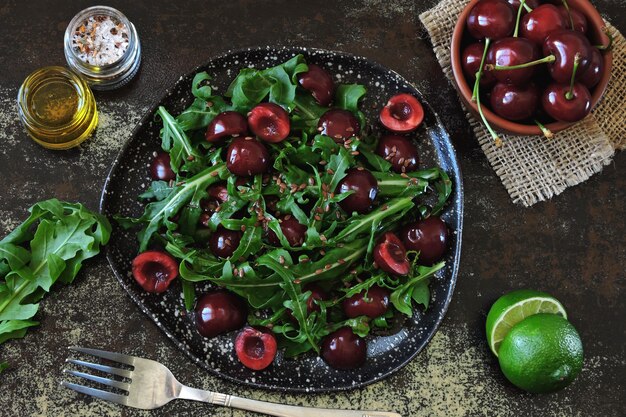 Ensalada dietética saludable con cerezas dulces y rúcula.