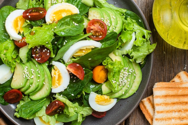 Ensalada con espinacas tomates aguacate en un plato Ensalada vegetariana