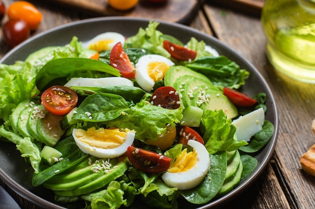 Ensalada con espinacas tomates aguacate en un plato Ensalada vegetariana