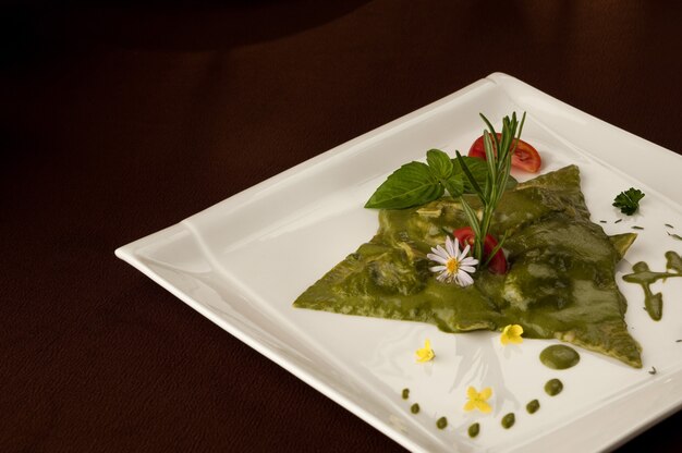 Ensalada de espinacas y tomates en un plato sobre un fondo oscuro