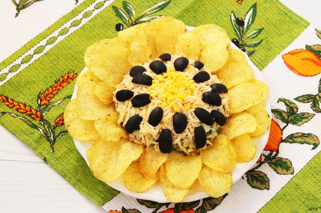 Ensalada en forma de girasol, decorada con papas fritas ubicadas en un plato