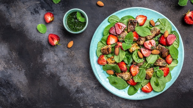 Ensalada de fresas frescas con hojas de espinaca, hígado de pollo, almendra y menta