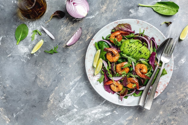 Ensalada fresca de aguacate y camarones. Concepto de mariscos. Sabrosas hojas mixtas de verduras, gambas a la plancha. banner, lugar de receta de menú para texto, vista superior.