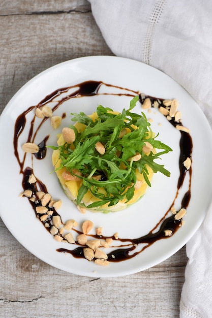 Ensalada fresca de aguacate, mango, mozzarella y rúcula sazonada con nueces