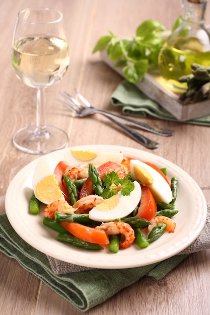 Ensalada fresca con espárragos, huevos, camarones y tomates.