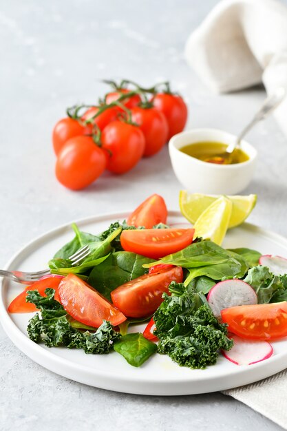 Ensalada fresca de espinacas, col rizada, tomates y rábanos con aceite de oliva y jugo de lima.