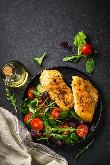 Ensalada fresca con filete de pollo y verduras en la mesa de la cocina negra Comida saludable dieta cetogénica baja en carbohidratos Vista superior con espacio de copia