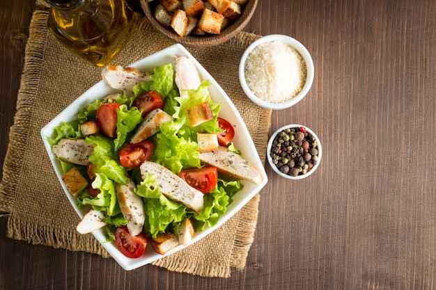 Ensalada fresca hecha de tomate, rúcula, pechuga de pollo, huevos, rúcula, galletas y especias.