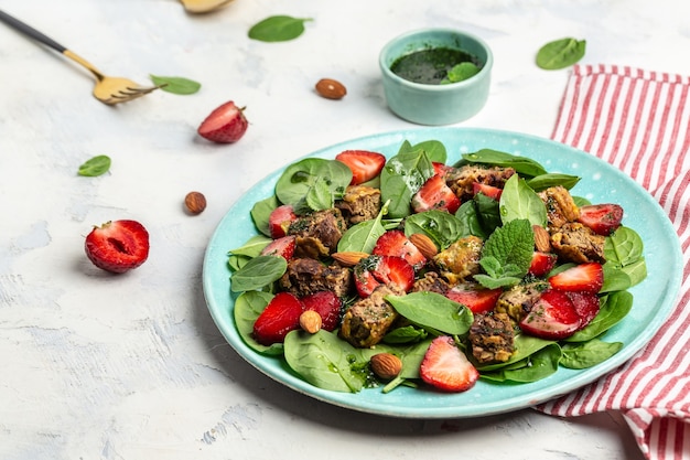 Ensalada fresca con hígado de pollo, espinacas, fresas, almendra y menta