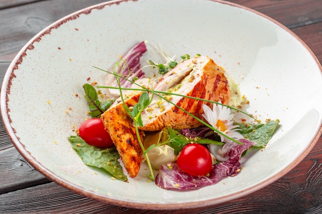 Ensalada fresca con pechuga de pollo, rúcula y tomate en un plato