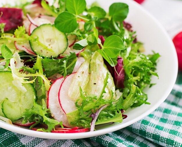 Foto ensalada fresca de pepinos, rábanos y hierbas.