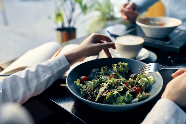 ensalada fresca en un plato comida deliciosa dieta tenedor en la mano manos femeninas café foto de alta calidad