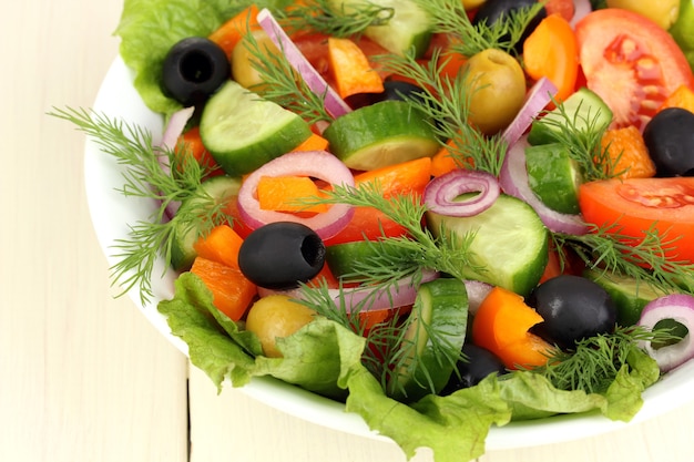 Ensalada fresca en plato sobre mesa de madera