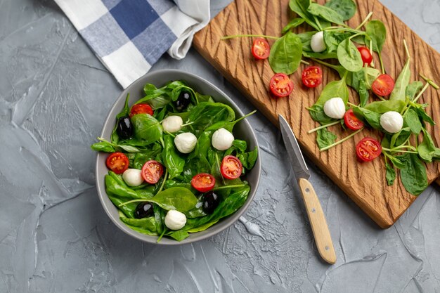 Ensalada fresca con queso mozzarella, tomate y espinacas. Alimentos dietéticos saludables.