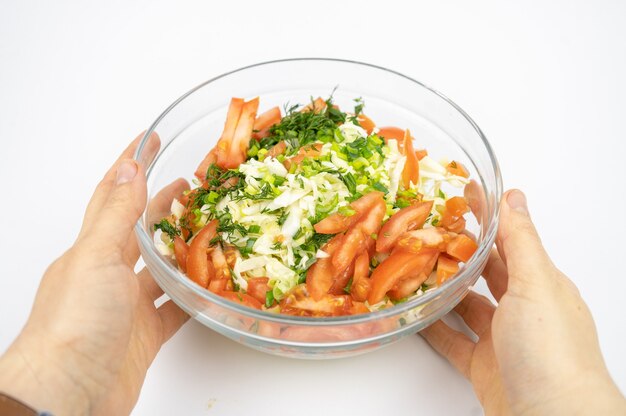 Ensalada fresca con repollo, tomates y verduras en un recipiente de vidrio