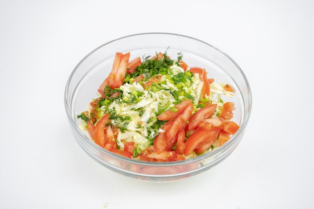 Foto ensalada fresca con repollo, tomates y verduras en un recipiente de vidrio