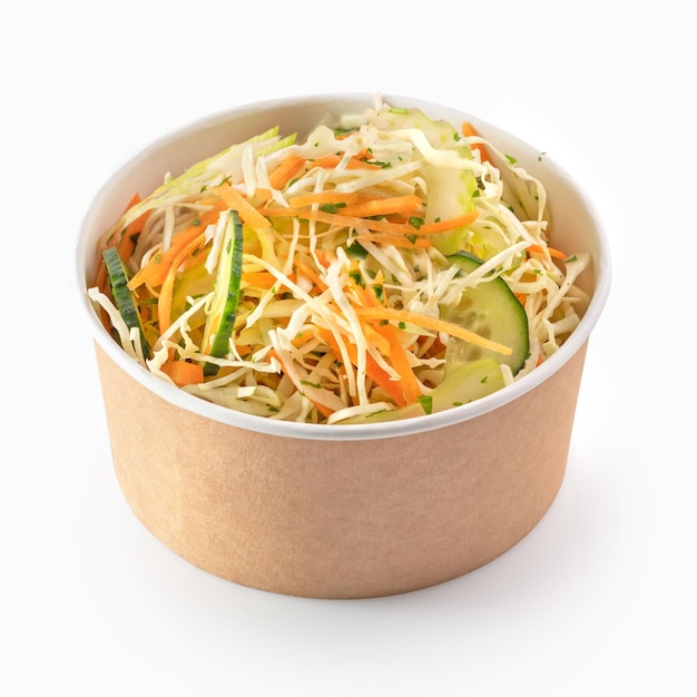 Ensalada fresca de repollo y zanahoria en un tazón de papel para llevar o entrega de comida aislada en un fondo blanco
