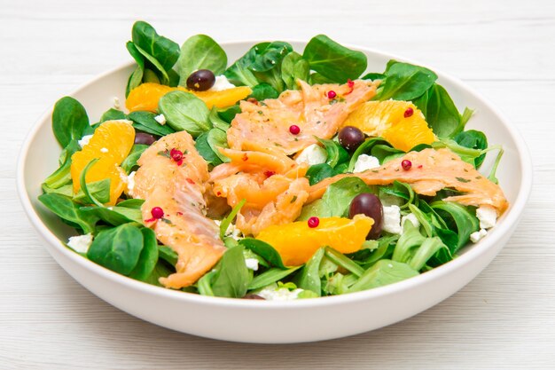 Ensalada fresca con rodajas de salmón marinado y naranja