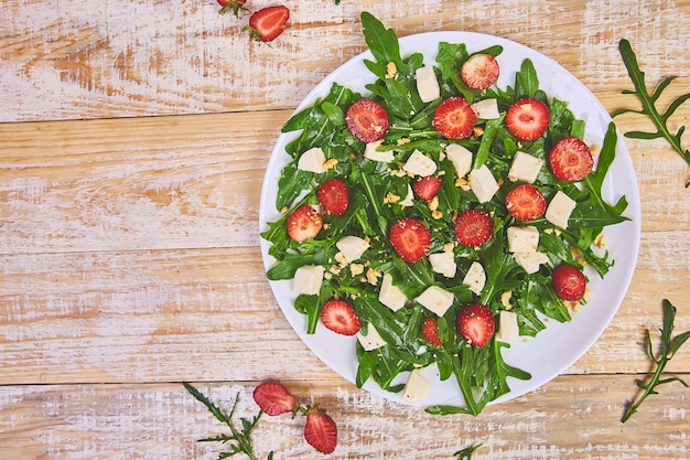 Ensalada fresca con rúcula, fresas, queso feta y nueces.