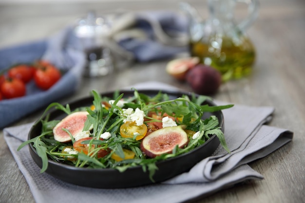 Ensalada fresca con rúcula, tomate y queso sobre fondo de madera