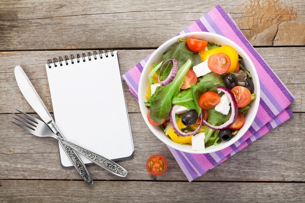 Ensalada fresca y saludable y libreta para espacio de copia