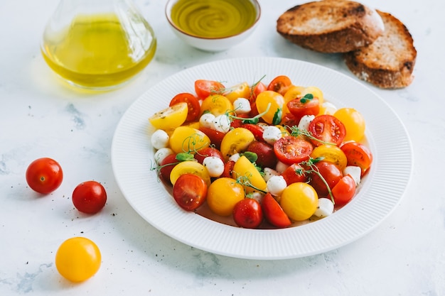 Ensalada fresca y saludable con tomates cherry, mozzarella y aceite de oliva