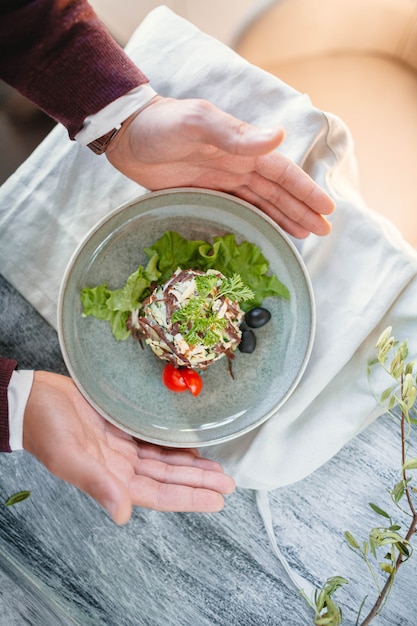 Foto ensalada fresca con ternera, aceitunas, ensalada y tomates en azul en una mesa de madera