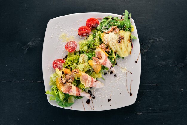 Ensalada fresca con tocino, aguacate y tomates Sobre un fondo de madera Vista superior Espacio de copia