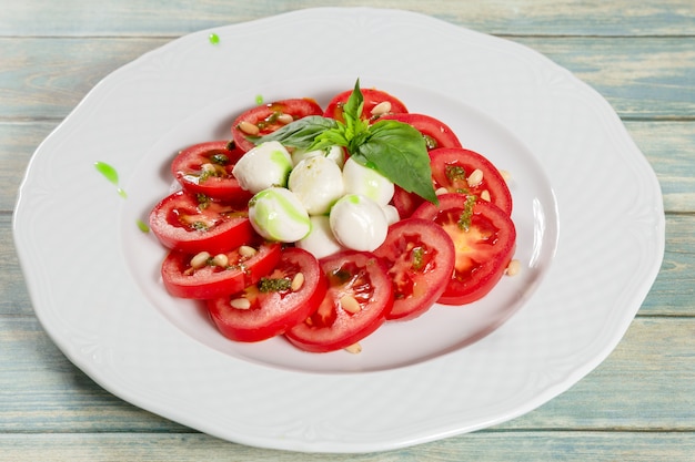 Ensalada fresca con tomates, queso mozzarella y salsa pesto.