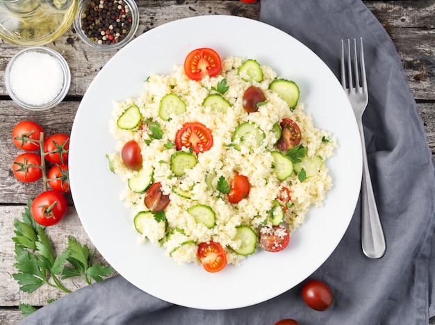 Ensalada fresca de vegetales con cuscús, tomates, pepinos, perejil,