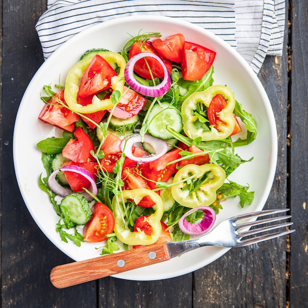 Ensalada fresca de vegetales, tomate, pepino, pimiento, cebolla, aceite de oliva, comida vegetariana saludable, merienda