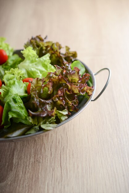 Ensalada fresca con verduras y verduras en la mesa de madera. Concepto de alimentos saludables.