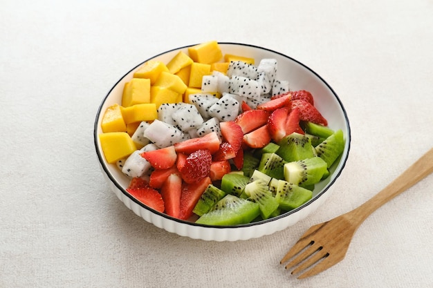 Ensalada de fruta fresca saludable tazón de fruta del dragón kiwi mango fresa en la mesa Enfoque seleccionado