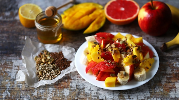 Ensalada de fruta jugosa fresca en un plato con mango, pomelo y semillas