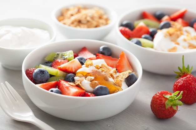 Ensalada de frutas y bayas con yogurt y granola para un desayuno saludable