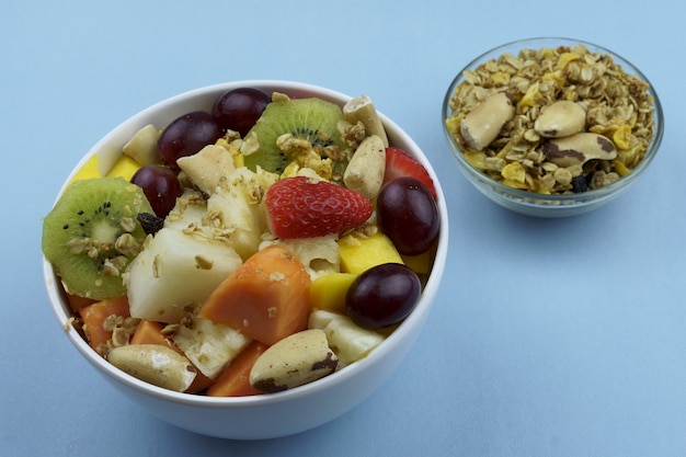 Ensalada de frutas con castañas y granola en un bol