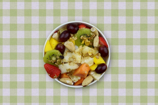 Ensalada de frutas con castañas y granola en un bol