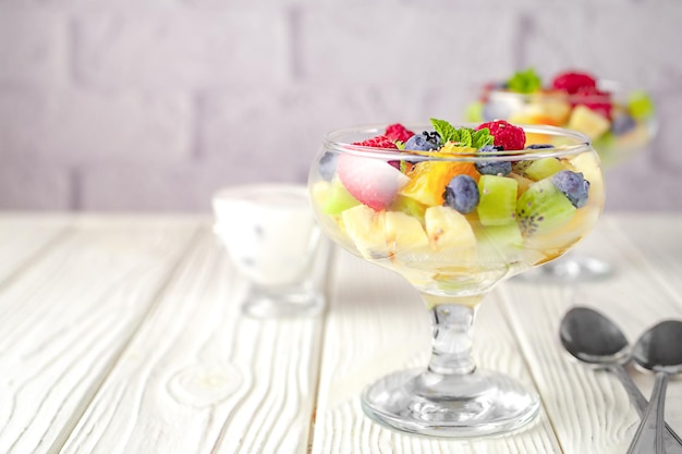 Ensalada de frutas frescas en un fondo de mesa de madera clara